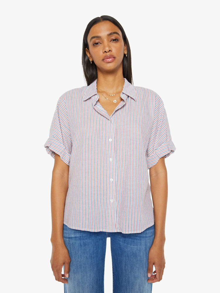 Front view of a woman short-sleeve button-downin red, white and blue stripes with a collared neck, drop shoulders, short sleeves with a rolled hem and a boxy fit.
