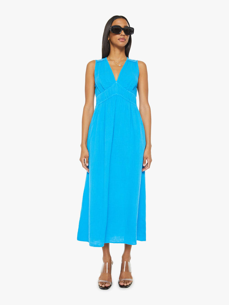 Front view of a woman sleeveless dress in blue, the Arwen dress features a V-neck, gathered, angled seams at the chest and a loose calf-length skirt.
