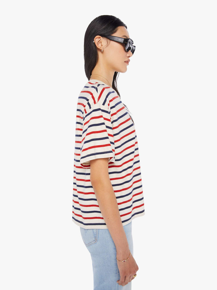 Side view of a woman wearing a boxy t-shirt with red, white, and blue stripes