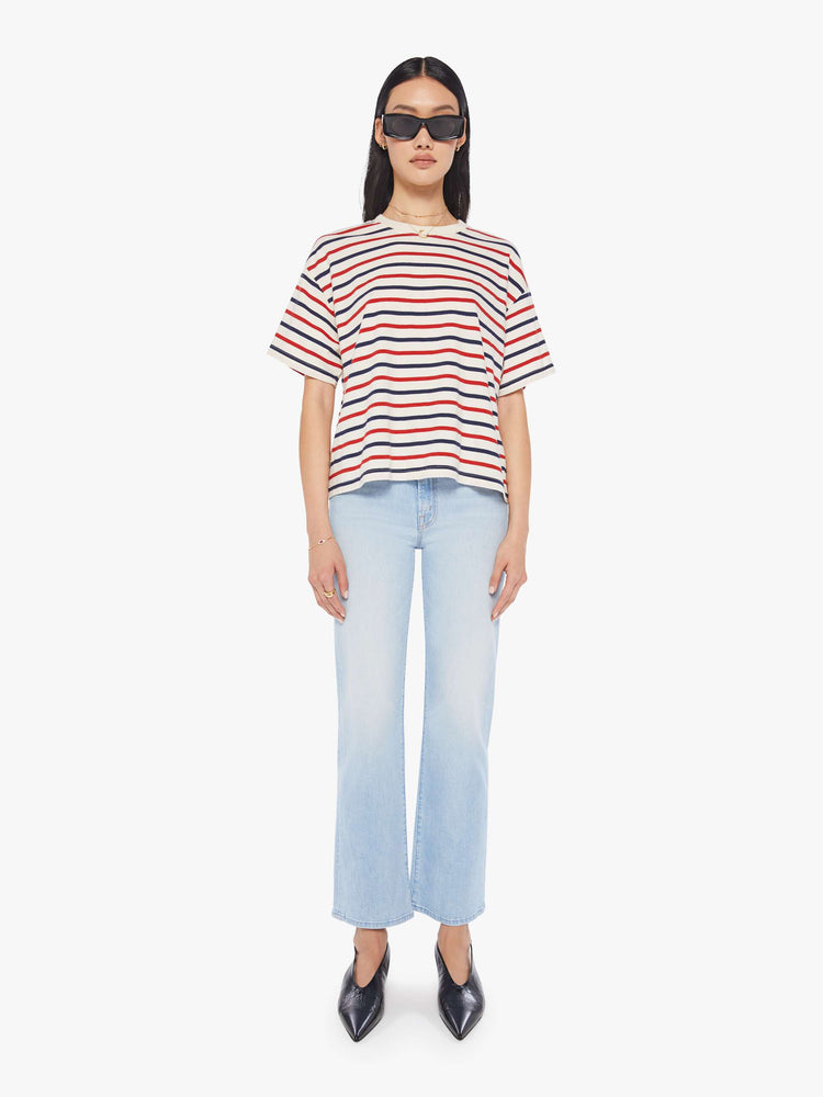 Front full body view of a woman wearing a boxy t-shirt with red, white, and blue stripes