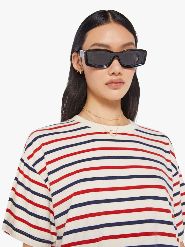 Detail view of a woman wearing a boxy t-shirt with red, white, and blue stripes