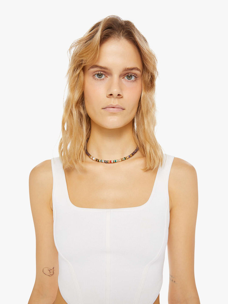 Front view of a woman wearing a beaded necklace on a brown vegan suede cord