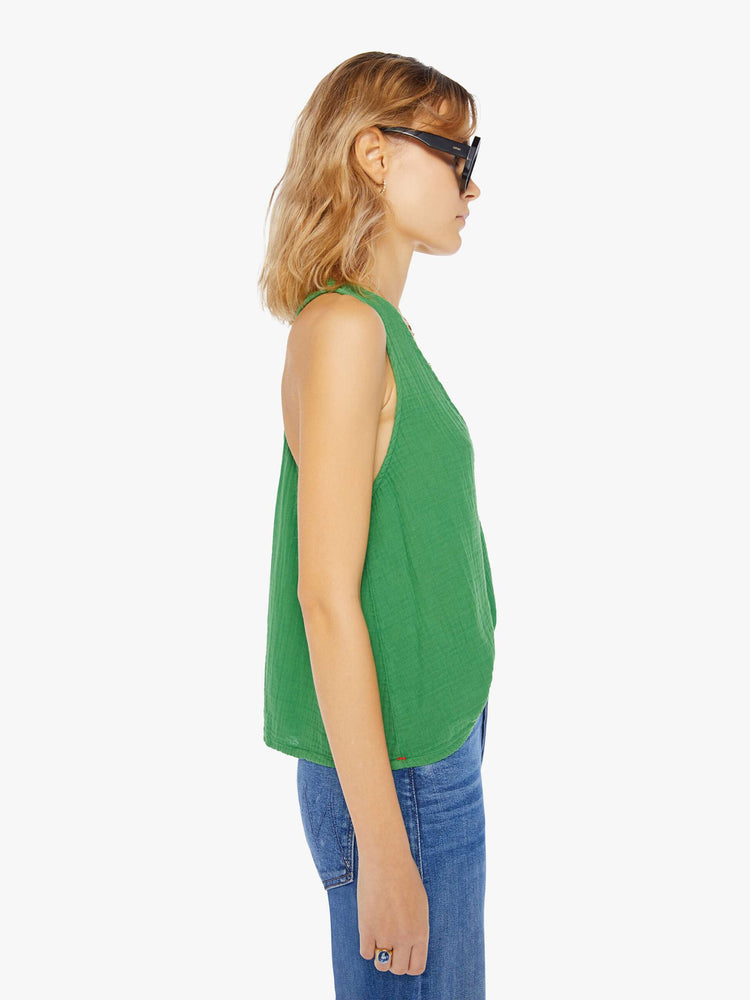Side view of a womens green top featuring a deep v neck and a loose boxy fit.