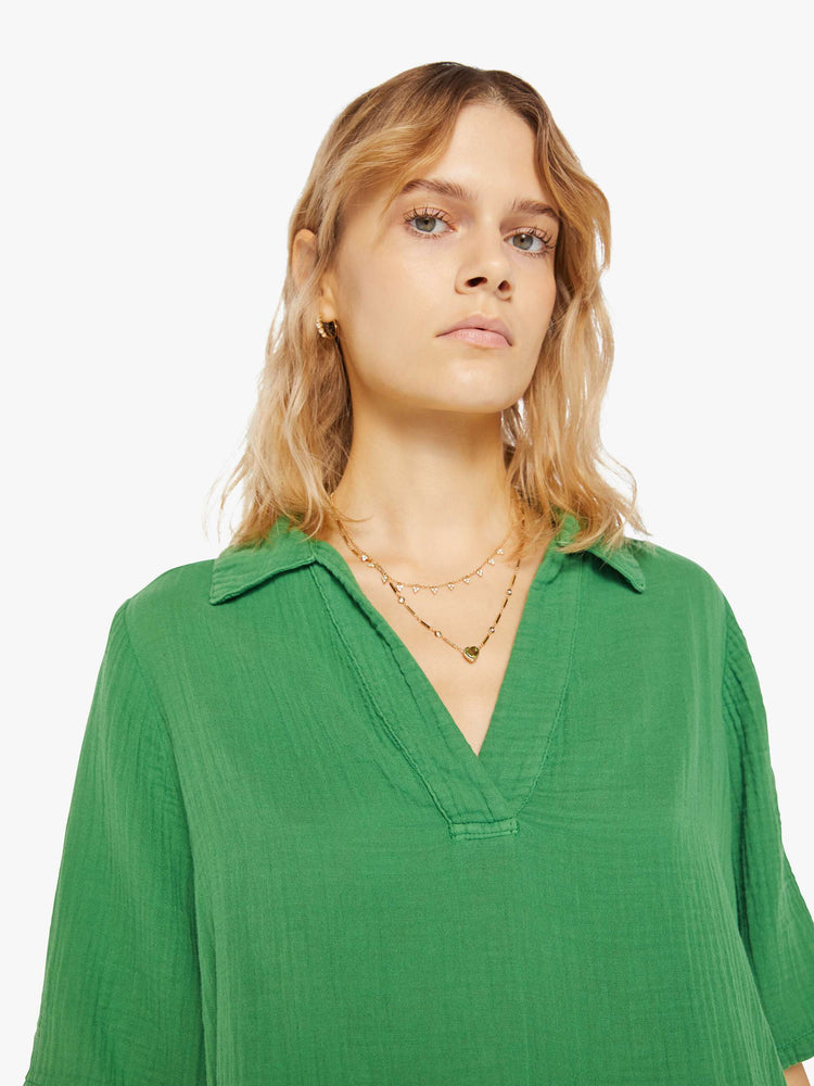 Front close up view of a womens green top featuring a v neck collar, 3/4 short sleeves, and a boxy cropped fit.