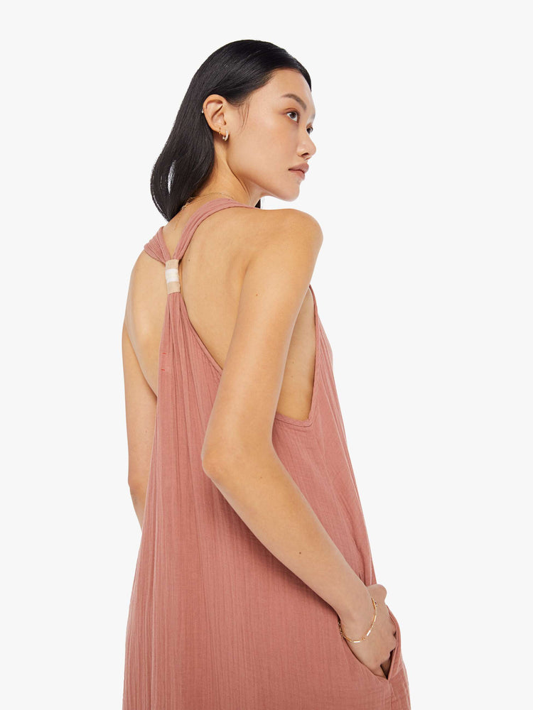 Back detail view of a womens dusty pink, ankle length dress featuring a deep v neck and a loose fit.