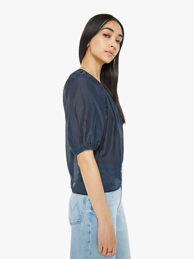 Side view of woman top in navy, the Blythe top features a ruffled V-neck with a keyhole detail, elbow-length balloon sleeves and a loose, flowy fit.