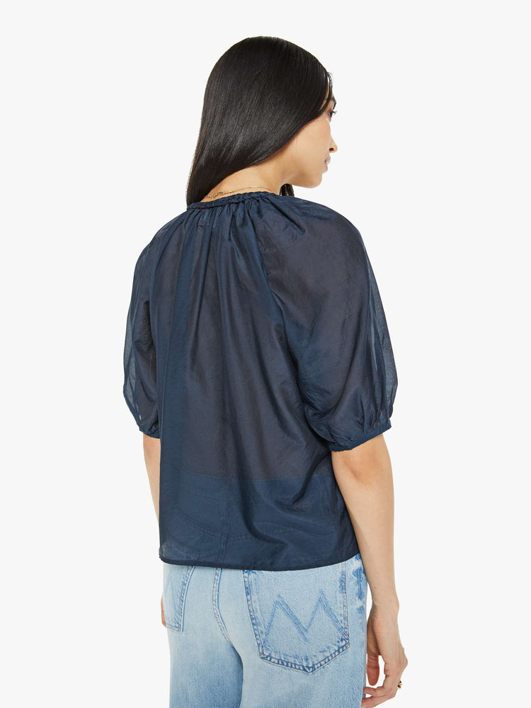 Back view of woman top in navy, the Blythe top features a ruffled V-neck with a keyhole detail, elbow-length balloon sleeves and a loose, flowy fit.