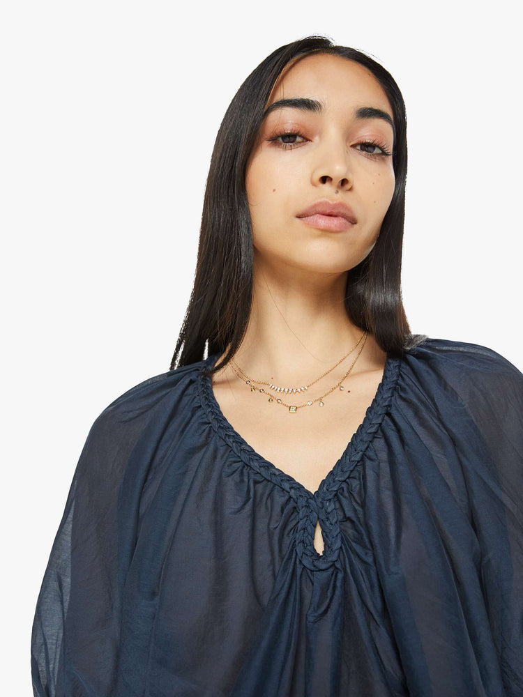 Close up view of woman top in navy, the Blythe top features a ruffled V-neck with a keyhole detail, elbow-length balloon sleeves and a loose, flowy fit.