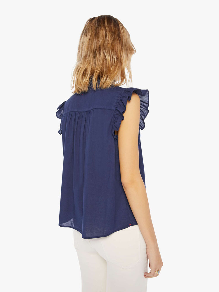 Back view of a navy blue blouse featuring a ruffled mock neck and sleeveless ruffles.