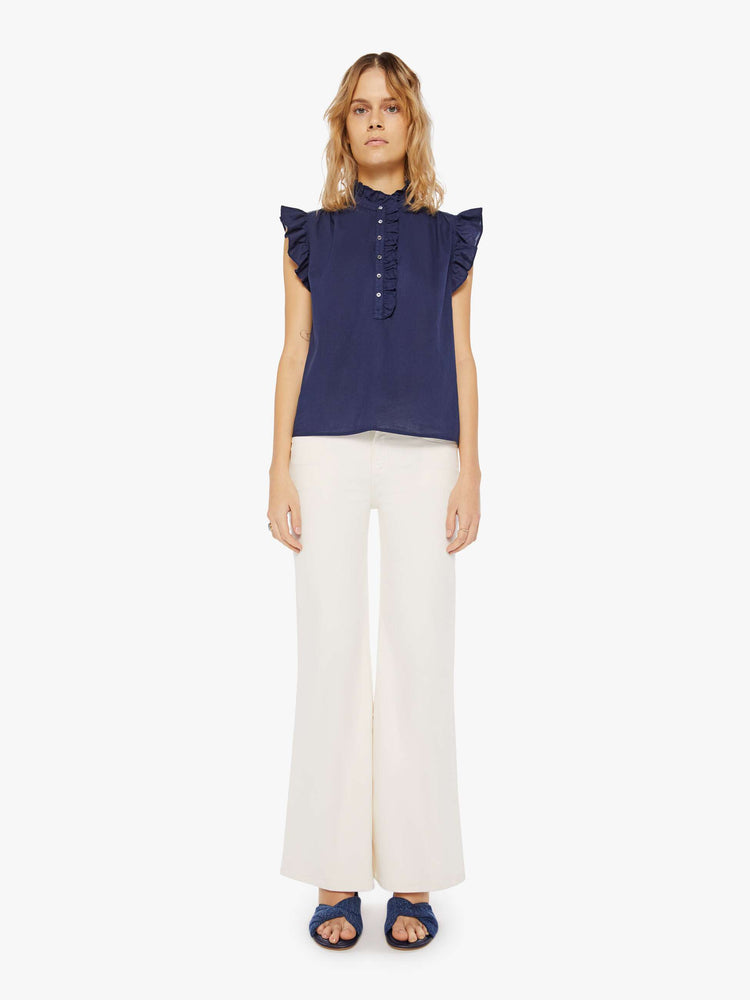 Front full body view of a navy blue blouse featuring a ruffled mock neck and sleeveless ruffles.