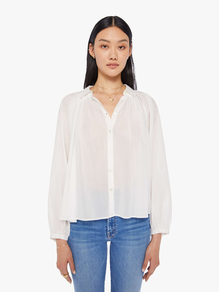 Front view of a womens white button down blouse featuring pleated shoulder details and balloon long sleeves.
