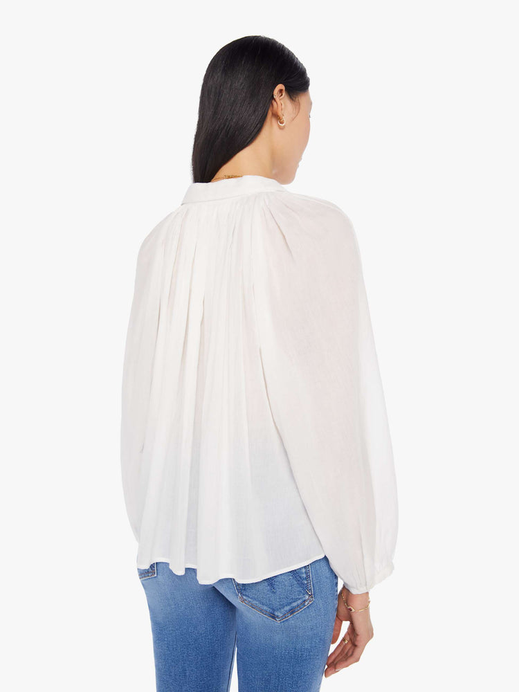 Back view of a womens white button down blouse featuring pleated shoulder details and balloon long sleeves.