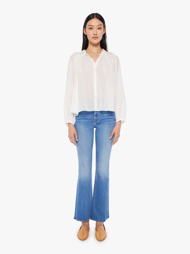 Front full body view of a womens white button down blouse featuring pleated shoulder details and balloon long sleeves.