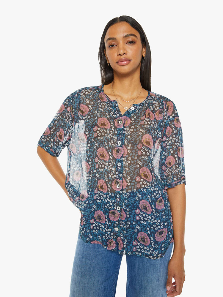 Front view of a woman top in dark teal with a pink and white vintage-inspired floral print, and features a deep V-neck, drop shoulders, elbow-length sleeves, a curved hem and a loose, flowy fit.