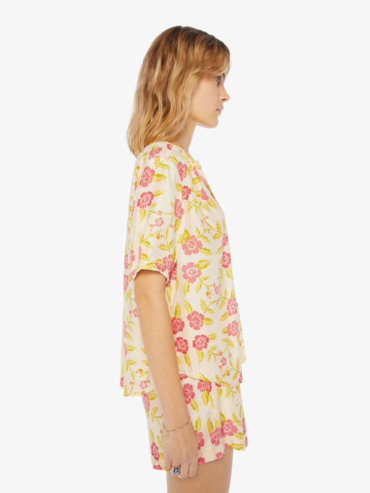 Side view of a womens short sleeve button down blouse, featuring short sleeves and a floral print.