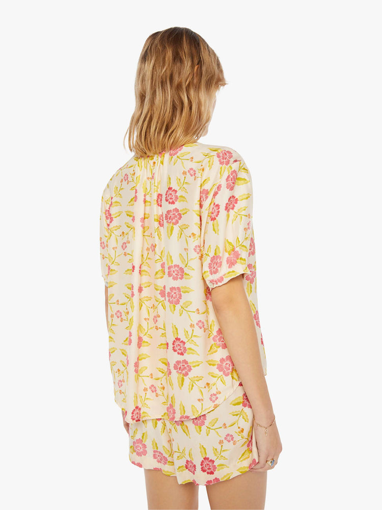 Back view of a womens short sleeve button down blouse, featuring short sleeves and a floral print.
