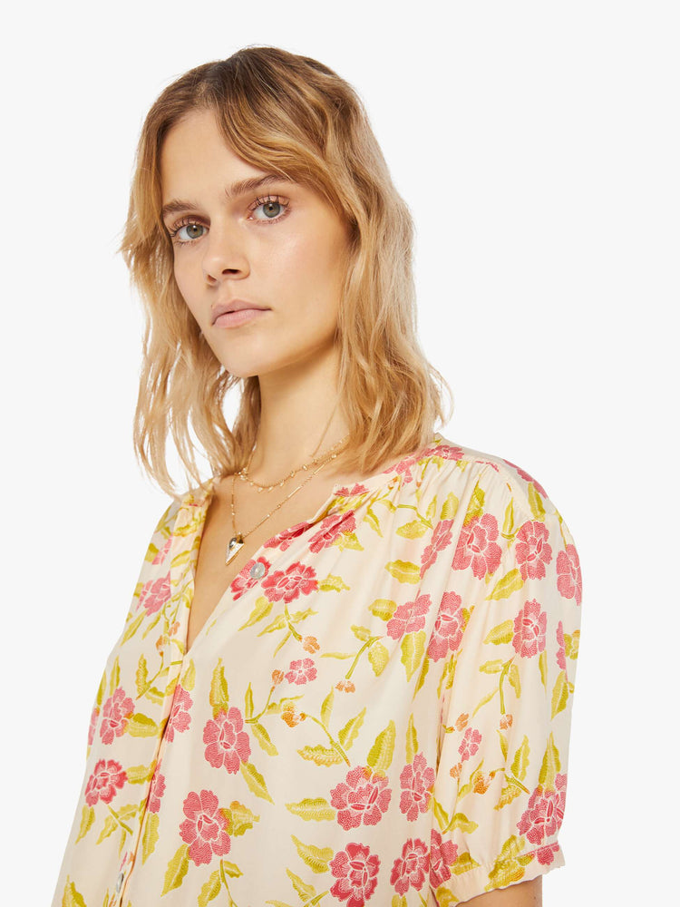 Front close up view of a womens short sleeve button down blouse, featuring short sleeves and a floral print.
