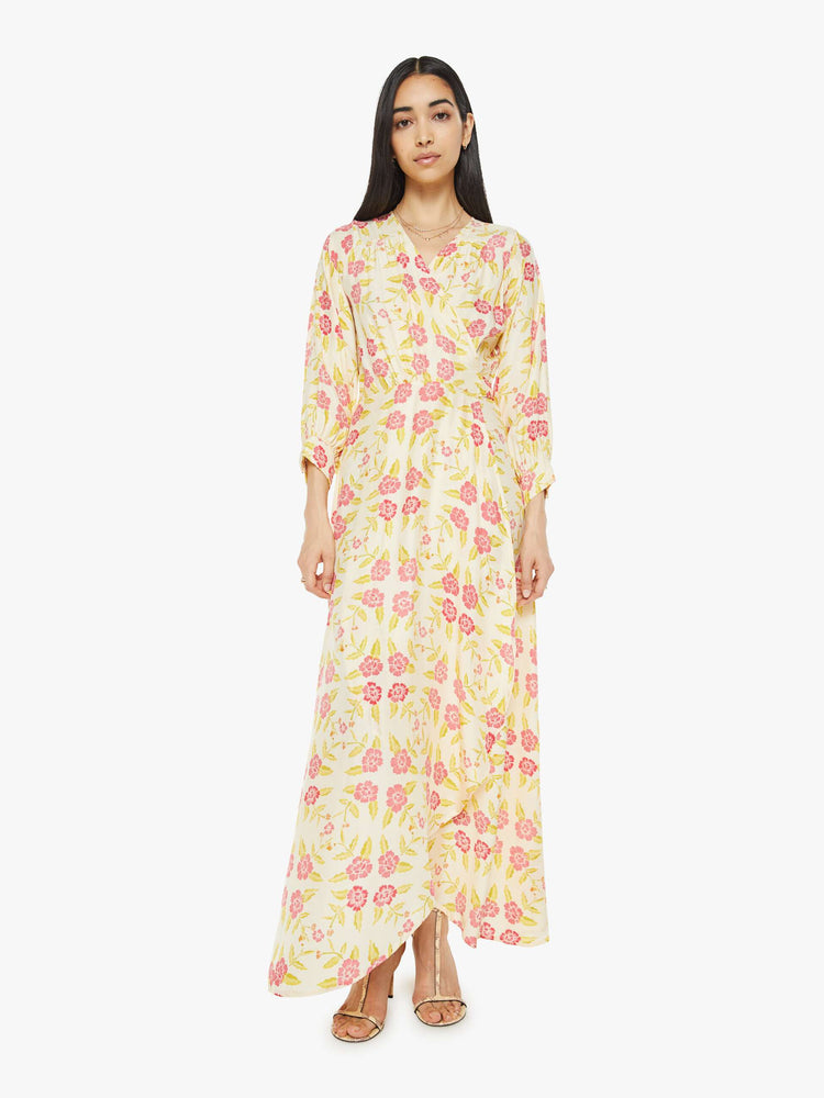 Front view of a woman long sleeve dress is made from 100% silk in a tropical floral print, and features a V-neck, tied waist and long maxi skirt with a loose, flowy fit.