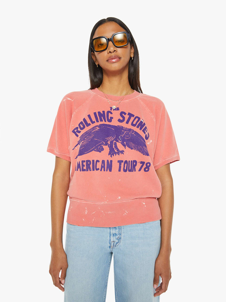 Front view of a woman short sleeve sweatshirt in red, the sweatshirt pays homage to The Rolling Stones' 1978 tour with a faded text graphic in navy on the front.
