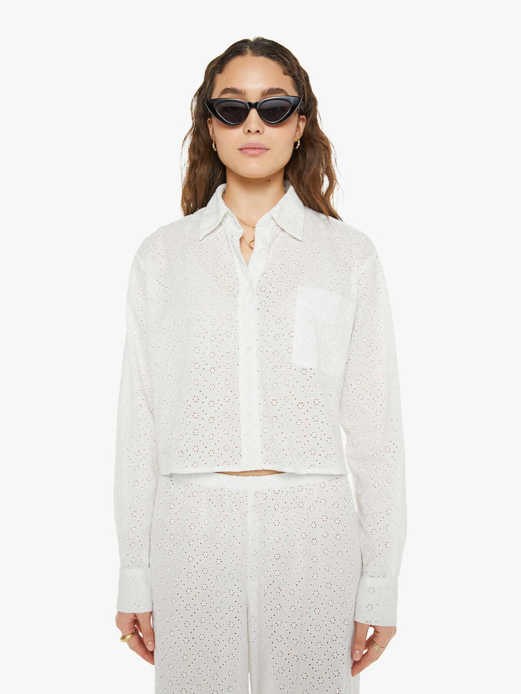 Front view of a woman white button up blouse with drop shoulders and a cropped, boxy fit.