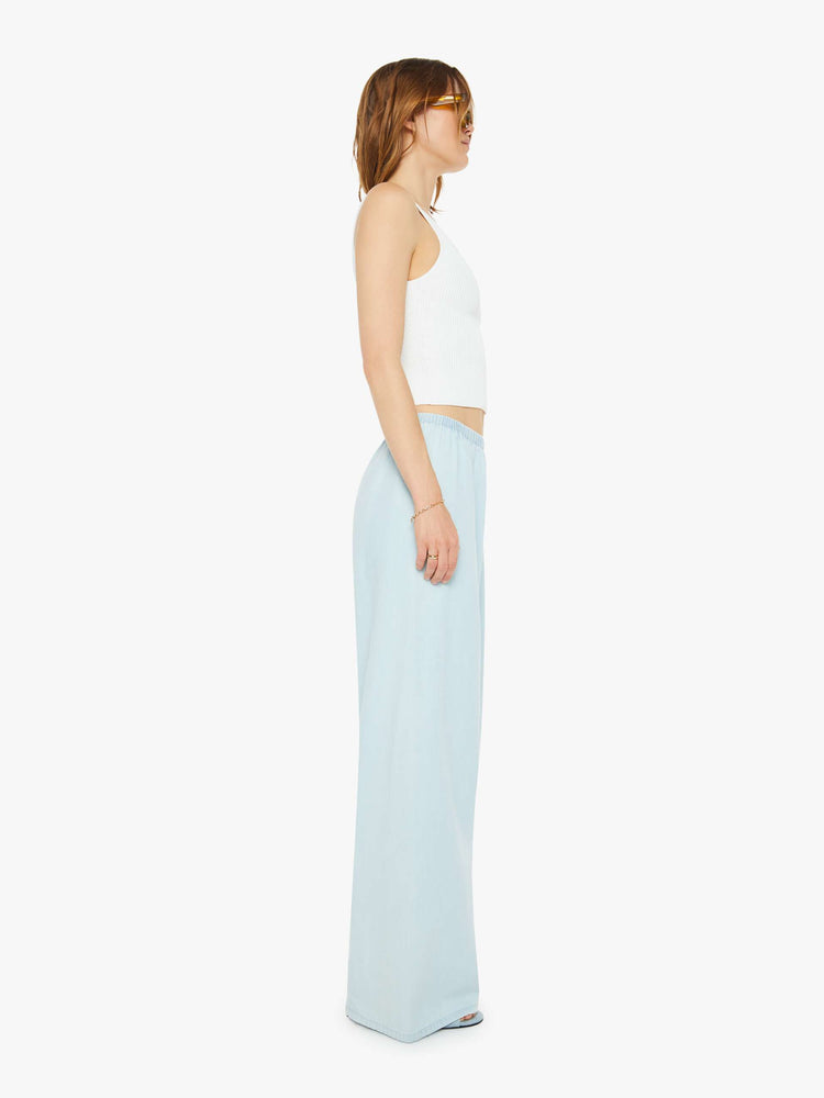 Side view of a woman sky blue pants with an elastic waistband and a comfortable fit.