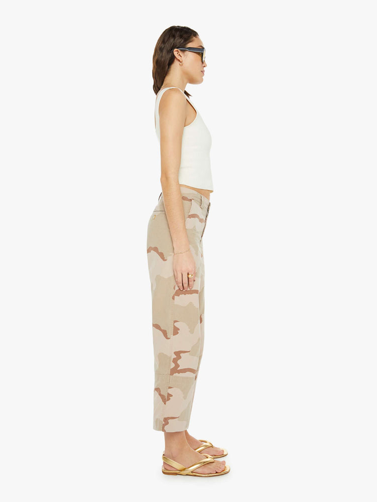 Side view of a woman in high rise, wide leg and ankle length inseam in khaki camouflage print, the trousers have a loose, comfortable fit.
