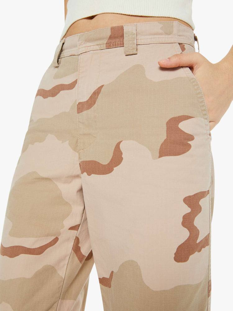 Swatch view of a woman in high rise, wide leg and ankle length inseam in khaki camouflage print, the trousers have a loose, comfortable fit.