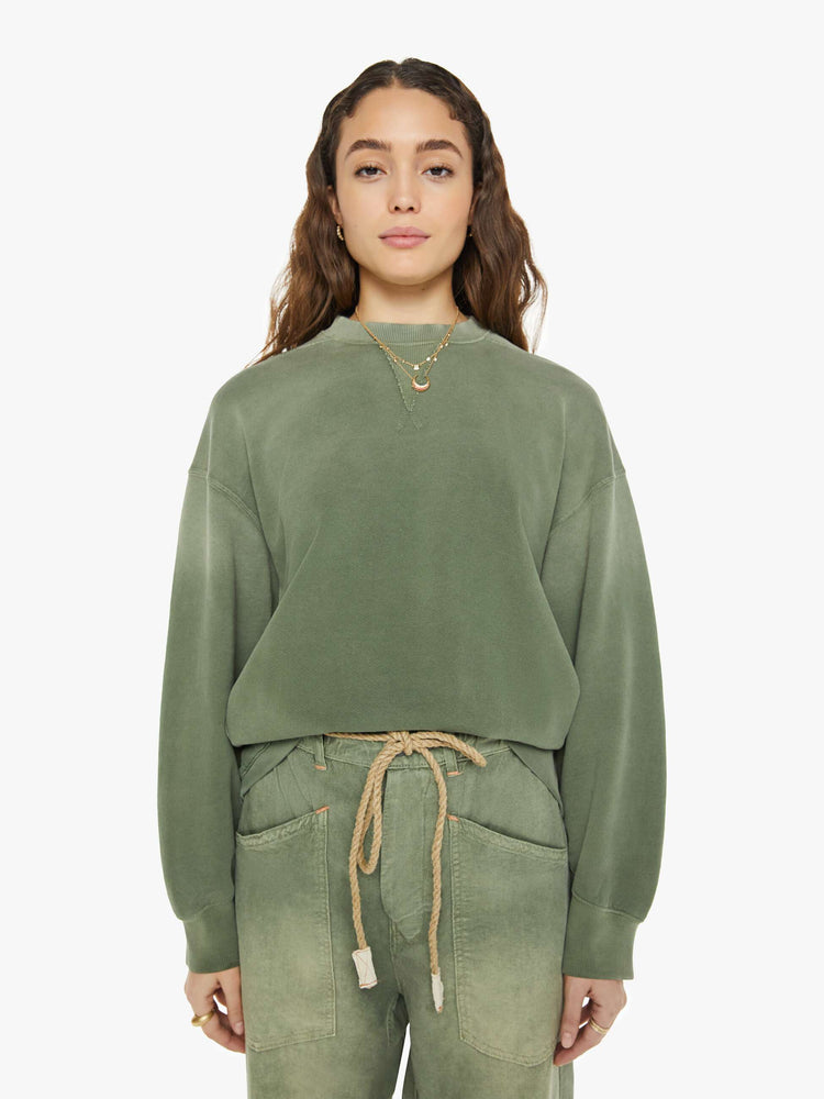 From view of a woman in a sweatshirt that features drop shoulders, long, oversized sleeves, ribbed hems and a loose fit. It's made from 100% cotton French terry in olive green.