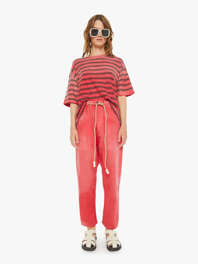 Full body view of a woman drop shoulders, short sleeves and a boxy fit in red with navy stripes.