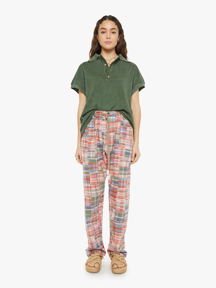 Front view of a woman in a patchwork graham pants have a mid rise, straight leg, patch pockets, drawstring waist with a woven belt and a loose fit.