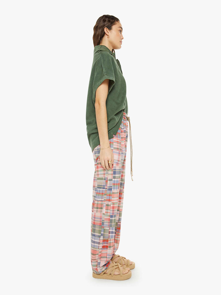 Side view of a woman in a patchwork graham pants have a mid rise, straight leg, patch pockets, drawstring waist with a woven belt and a loose fit.