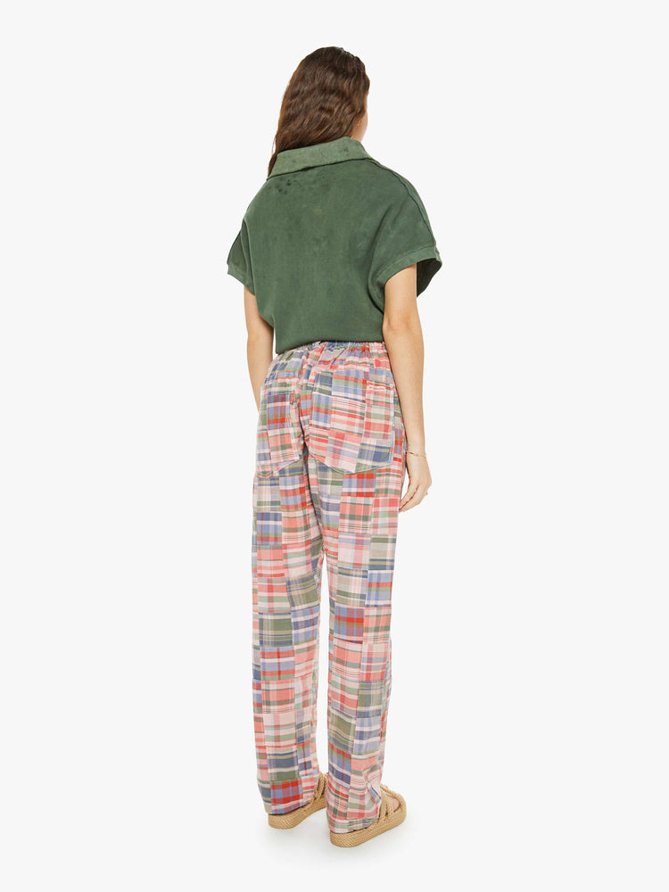 Back view of a woman in a patchwork graham pants have a mid rise, straight leg, patch pockets, drawstring waist with a woven belt and a loose fit.