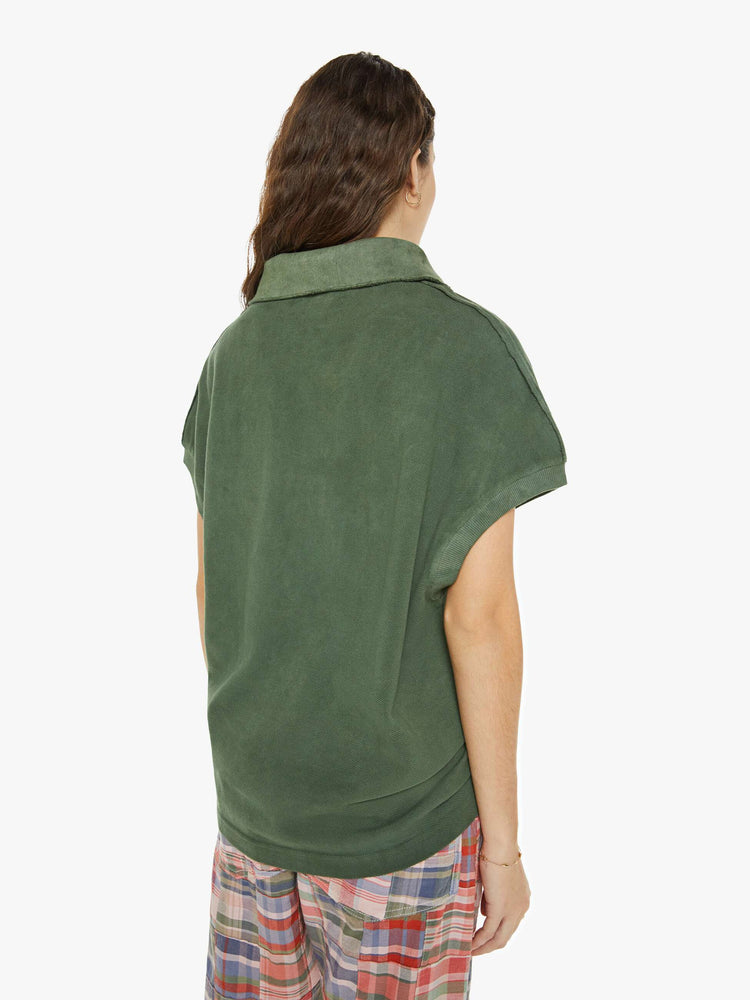 Back view of a woman in a short-sleeve polo shirt is designed with a four-button placket, a patch pocket at the hip and a loose fit in a military green.