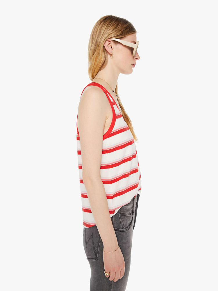 Side view of a woman in a white tank with red trim and stripes.