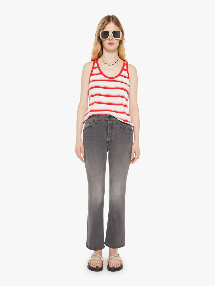 Full body  view of a woman in a white tank with red trim and stripes.