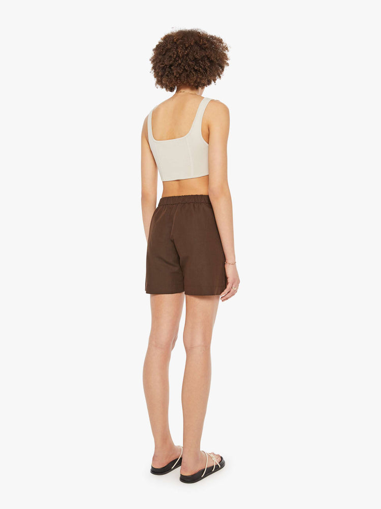 Back  view of a woman in brown high rise slit pockets shorts.
