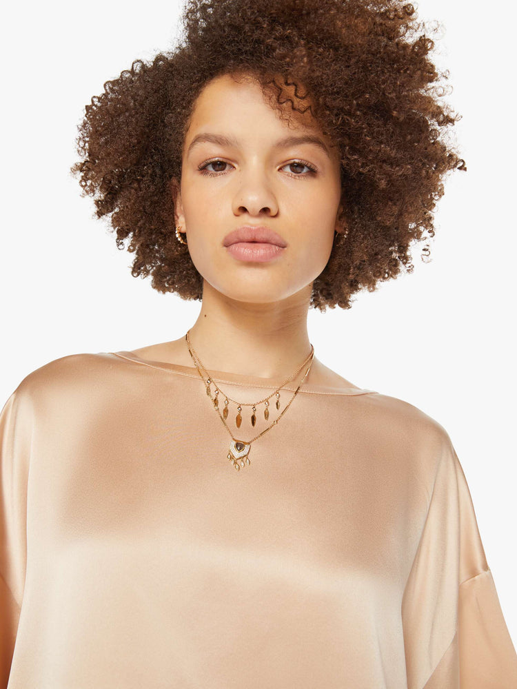 Close up view of a woman in a neutral pink silk crewneck tee.