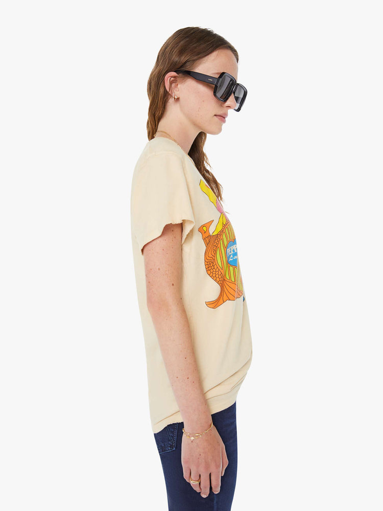 WOMEN side view in a tea-stained white tee that pays homage to The Beatles with a colorful graphic on the front.