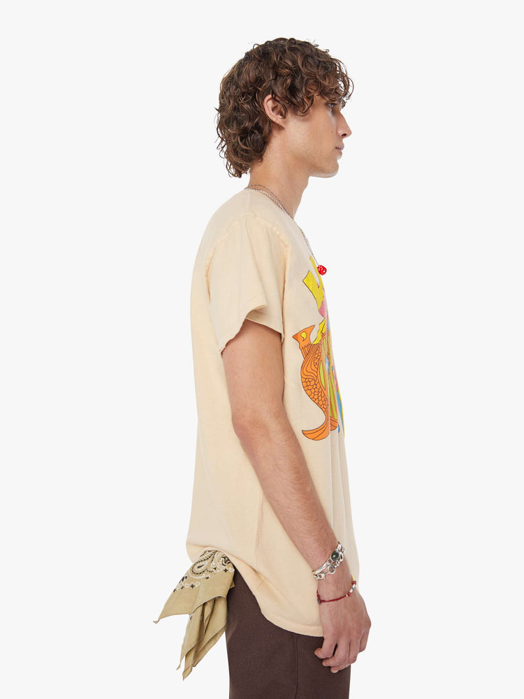 MEN side view in a tea-stained white tee that pays homage to The Beatles with a colorful graphic on the front.