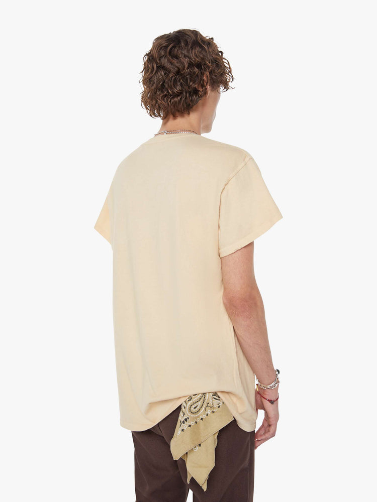 MEN back view in a tea-stained white tee that pays homage to The Beatles with a colorful graphic on the front.