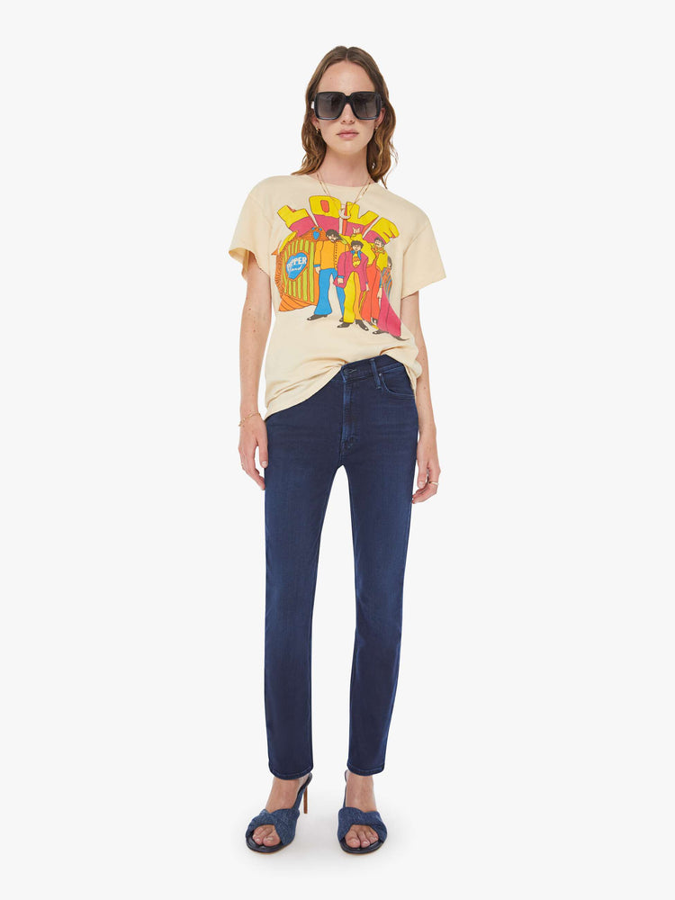 WOMEN full body view in a tea-stained white tee that pays homage to The Beatles with a colorful graphic on the front.