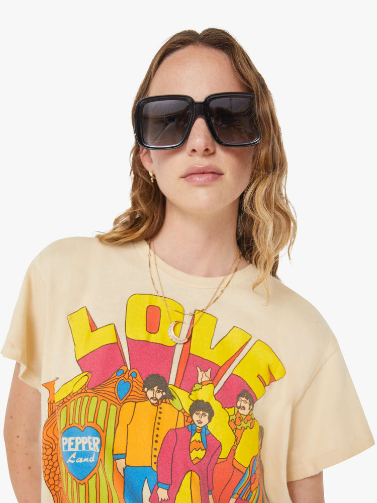 WOMEN close up view in a tea-stained white tee that pays homage to The Beatles with a colorful graphic on the front.