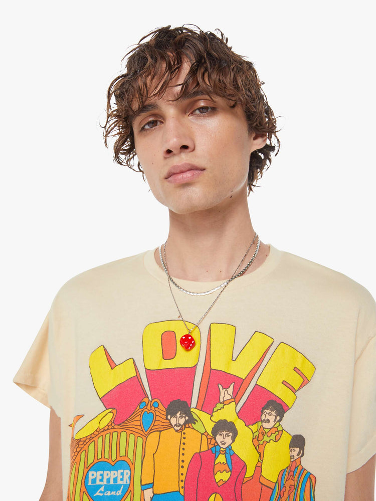 MEN close up view in a tea-stained white tee that pays homage to The Beatles with a colorful graphic on the front.