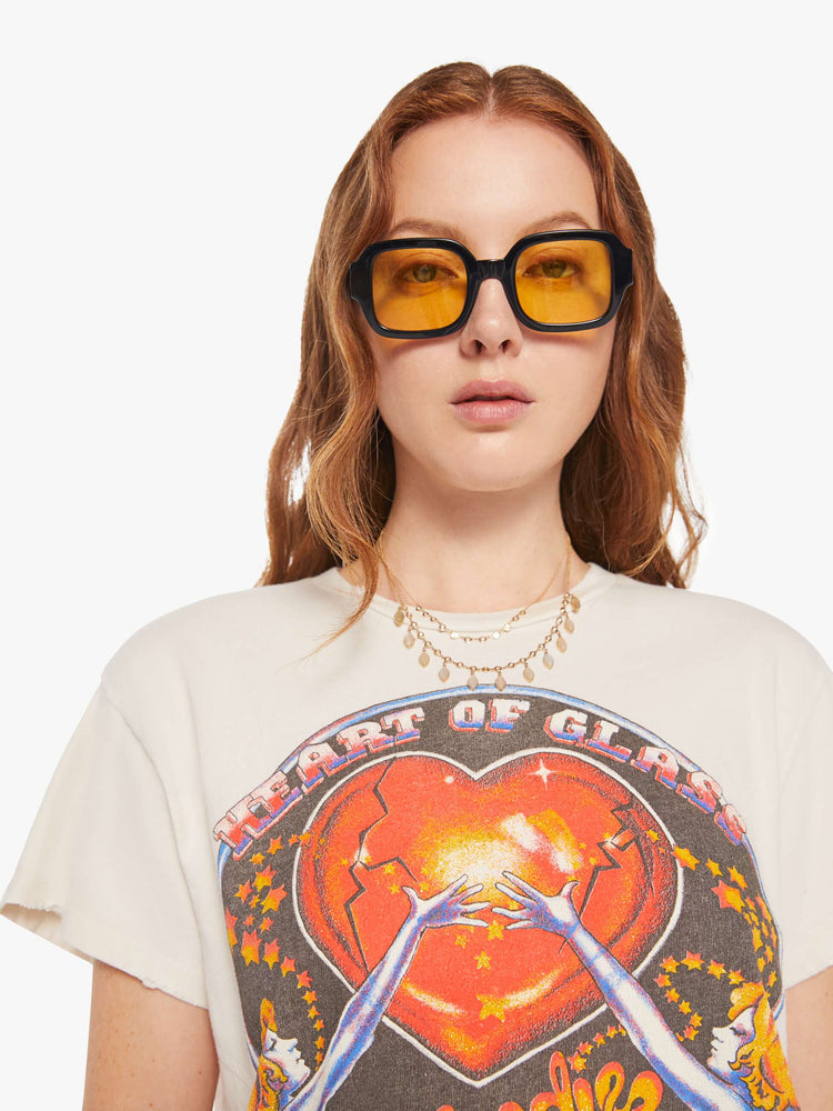 Close up view of a woman in a white tee that  pays homage to Blondie with a graphic on the front.