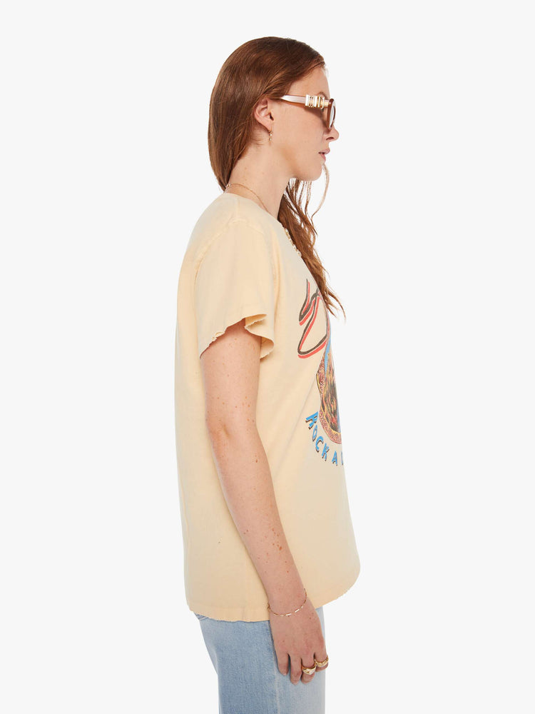 Side view of a woman in a light yellow, the tee pays homage to Stevie Nicks' Rock A Little tour with a graphic portrait on the front.