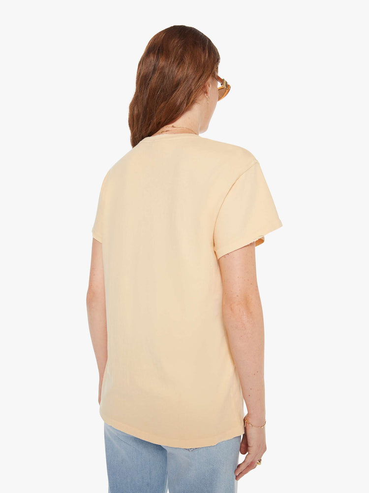Back view of a woman in a light yellow, the tee pays homage to Stevie Nicks' Rock A Little tour with a graphic portrait on the front.