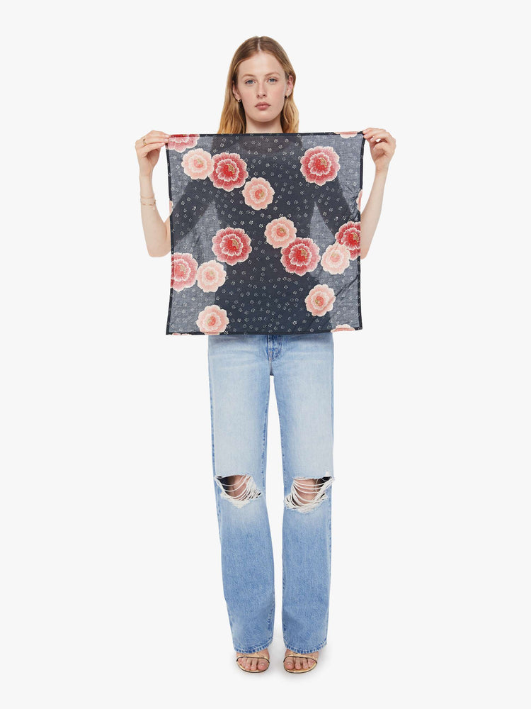 Model holding a indigo with a pink poppy print scarf.