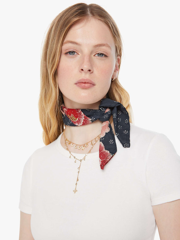 Close up view of a model in an indigo with a pink poppy print scarf.