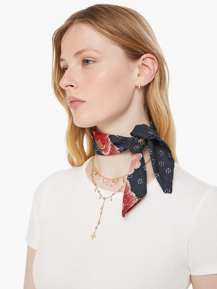 Close up view of a model in an indigo with a pink poppy print scarf.