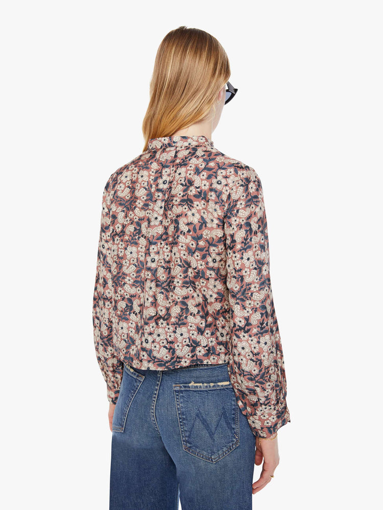 Back view of a woman pink, black and white floral print shirt with  V-neck that ties, long balloon sleeves and a slightly cropped fit.